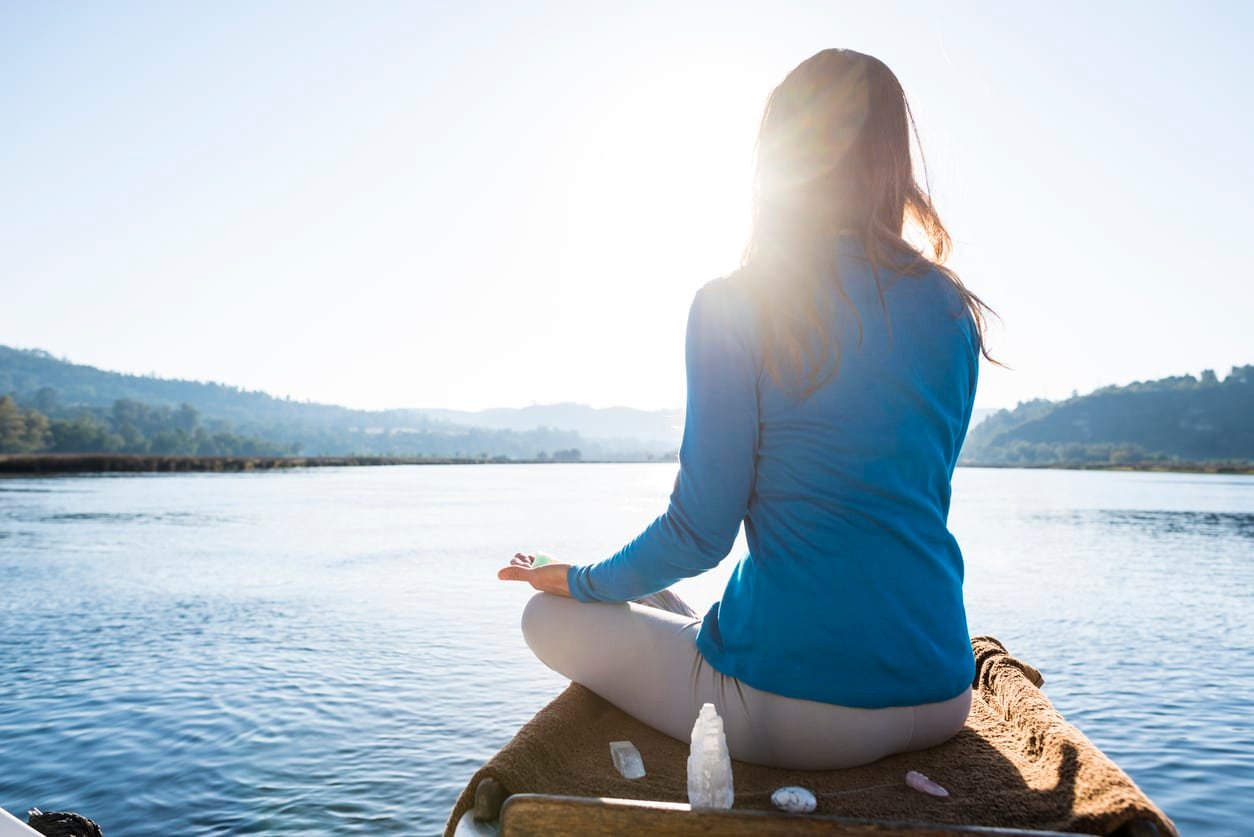 A propos 2 Femme qui medite avec des pierres naturelles